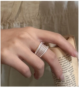 Close-up of a stacked silver multi-layer ring with textured beaded and twisted details