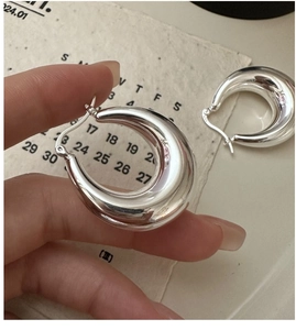 Close-up of high-polished S925 silver chunky hoop earrings with a mirror-like finish