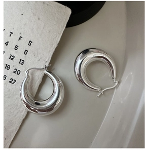 Macro shot of polished S925 sterling silver chunky hoop earrings with a glossy finish