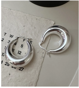 Close-up of S925 sterling silver hallmark on chunky hollow hoop earrings surface