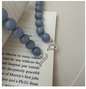 Detail of grey-blue beaded necklace with silver asymmetric T-bar toggle clasp