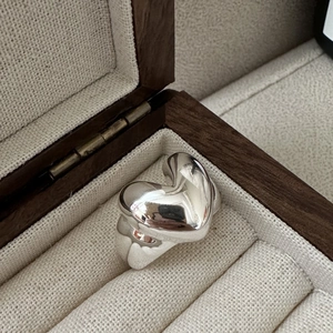Polished S925 sterling silver heart ring displayed in a vintage wooden jewelry box