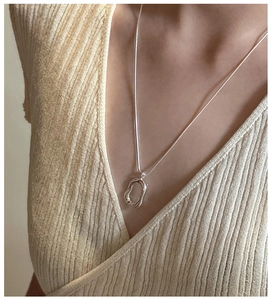 Detail of S925 silver O-chain necklace with irregular lava pendant on a model