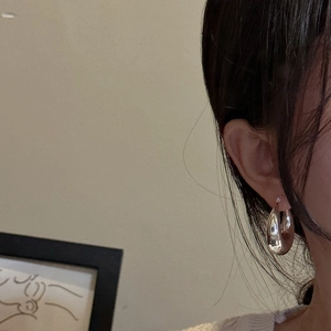 Minimalist S925 sterling silver hollow C-shaped hoop earrings worn on ear for women