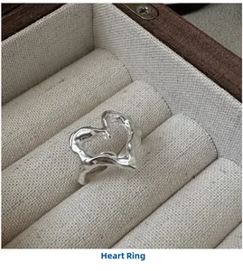 Macro view of a silver heart ring featuring unique lava texture in a beige jewelry box