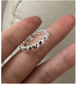 Macro detail of silver twisted rope ring showing polished metallic texture and open band