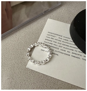 Macro view of S925 sterling silver beaded open ring showing polished metallic texture