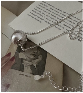 Close-up of S925 sterling silver cat-eye bead necklace with textured sphere pendant