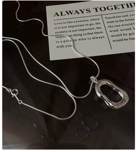 Detail of minimalist S925 sterling silver long O-chain with organic oval pendant