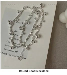 Detail view of S925 sterling silver beaded necklace with heart charm on book background