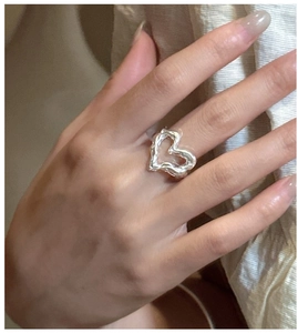 Detail of S925 silver heart ring with molten lava texture shown on finger