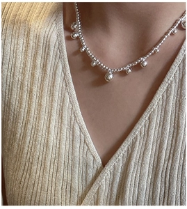 Close-up of minimalist S925 sterling silver beaded necklace worn on a female neck