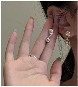 Close-up of stylish S925 silver water drop earrings and textured ring on a model
