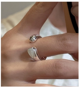 Detail of adjustable S925 silver ring featuring asymmetrical opal and metal teardrops