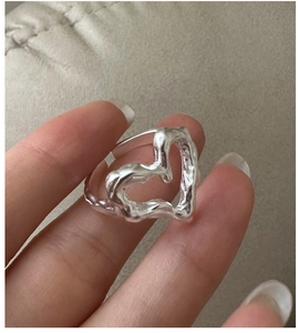 Detail of S925 silver heart ring featuring unique molten lava texture on a model finger