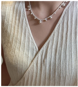 Close-up of S925 sterling silver beaded necklace worn on a soft knit sweater