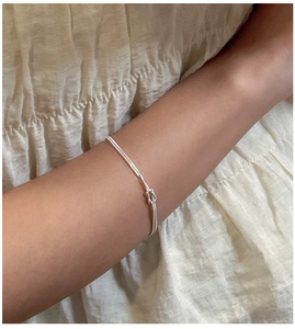 Nahaufnahme von silbernem S925 zweilagigem Schlangenkette-Armband mit Knotendetail
