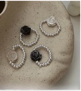 Macro view of S925 silver beaded rings with black and white rose flower charms