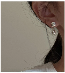 Close-up of S925 sterling silver teardrop earrings on model with high polished finish