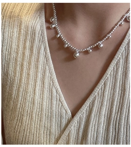 Close-up of S925 sterling silver beaded necklace with polished sphere pendants on model