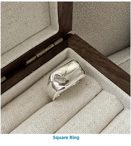 Detail of square zircon silver ring displayed in a luxury wooden jewelry gift box