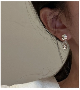 Close-up of S925 sterling silver drop earrings with geometric polished finish on model
