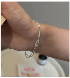 Detailansicht eines minimalistischen S925 Silber Doppel-Schlangenketten Armbands mit Knoten
