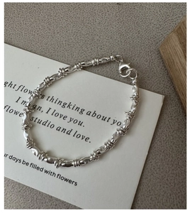 Close-up of S925 sterling silver bracelet featuring spiral textured beads and lobster clasp