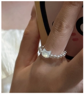 Macro shot of S925 sterling silver beaded ring with white cat-shaped mother-of-pearl charm