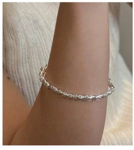 Macro detail of S925 silver bracelet featuring spiral bamboo-shaped textured links