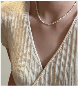 Gros plan du collier en argent torsadé montrant la texture scintillante du métal poli