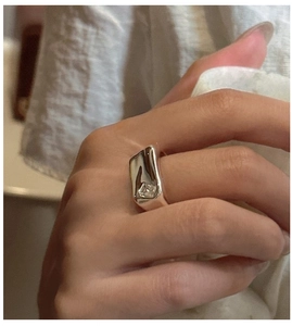 Detailed close-up of a silver molten lava ring with square zircon on a hand