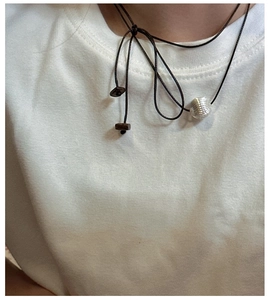 Close-up of S925 sterling silver textured bead pendant on minimalist black cord necklace