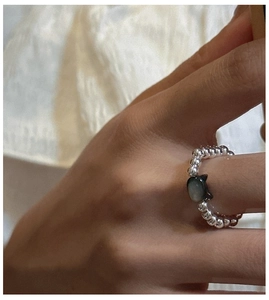 Close-up of S925 sterling silver beaded ring with a black shell cat charm on elastic cord