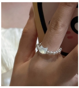 Detail of s925 silver beaded cat ring with white mother of pearl on a finger
