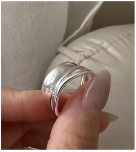 Close-up detail of S925 sterling silver layered pleated ring with polished finish