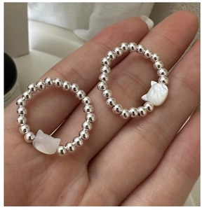 Detailed view of elastic S925 silver beaded rings with cat-shaped mother of pearl charms
