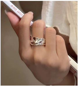 Close-up of a wide silver S925 ring with irregular wavy layers and a polished mirror finish