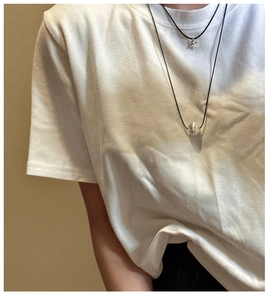 Detail of S925 silver star and textured bead pendants on minimalist black cord necklace