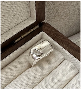 Macro shot of silver molten lava ring with rectangular zircon in a luxury wood box