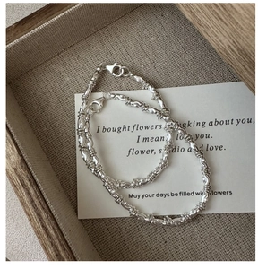 Detail of S925 sterling silver twisted chain bracelet with lobster clasp on a tray