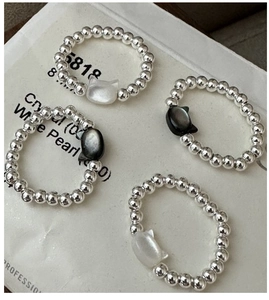 Detailed macro view of S925 silver beaded rings set with iridescent cat shell pendants