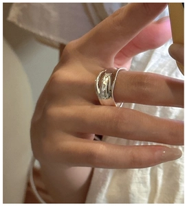 Close-up of a double-layered pleated S925 sterling silver ring with liquid metal wave design