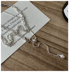 Détail du collier de perles triple couche réglable en argent S925 avec pendentif pomme de pin