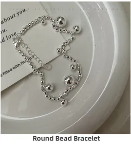 Macro shot of S925 sterling silver beaded bracelet with spherical charms on white porcelain
