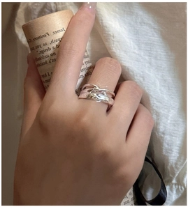 Detail of S925 sterling silver crisscross ring on finger with vintage paper background