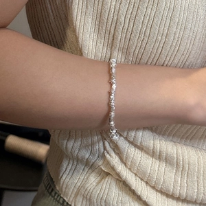 Minimalist S925 sterling silver bracelet with irregular textured beads on a model's wrist