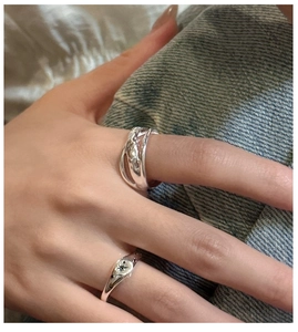 Close-up of S925 silver overlapping ring and starburst engraved signet ring set