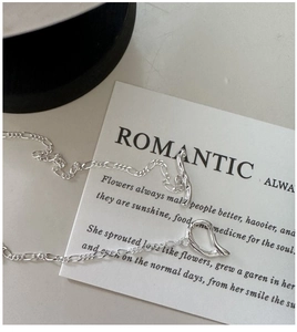 Detail of S925 silver Figaro chain with T-bar toggle closure and irregular ring pendant