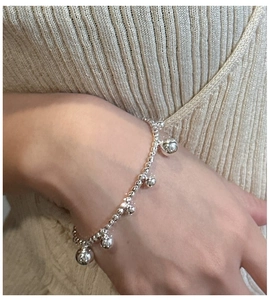 Detail of S925 sterling silver beaded bracelet with spherical pendants on a female wrist